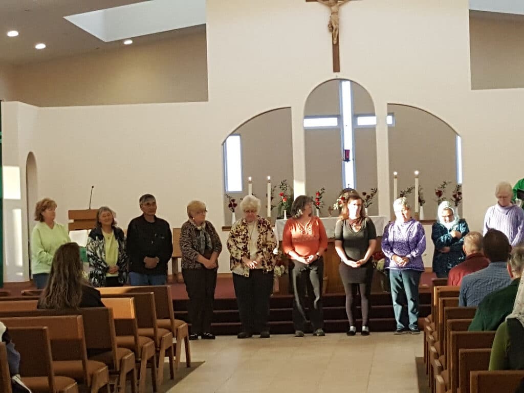 Group of people standing in line in front of the church stage